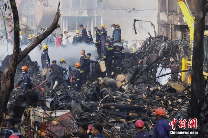 当地时间6月12日，印度航空一架客机在执飞艾哈迈达巴德至伦敦盖特(📈)威克航线时在飞行过程中坠毁，航班上共有242人。据外媒报道称，飞机坠毁在当地的一所医学院的宿舍区内。据路透社报道，现场找到的尸体可能包括乘客与地面的遇难者。根据现场拍摄的照片和视频显(🧓)示，飞机残骸散落在建筑物周围，机身卡在了建筑物顶部。图为搜救队在飞机坠毁现场进行救援。图/视觉中国